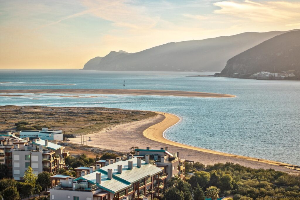 Vue aérienne d'une plage et de montagnes au Portugal. Des maisons se trouvent dans le bas de l'image.