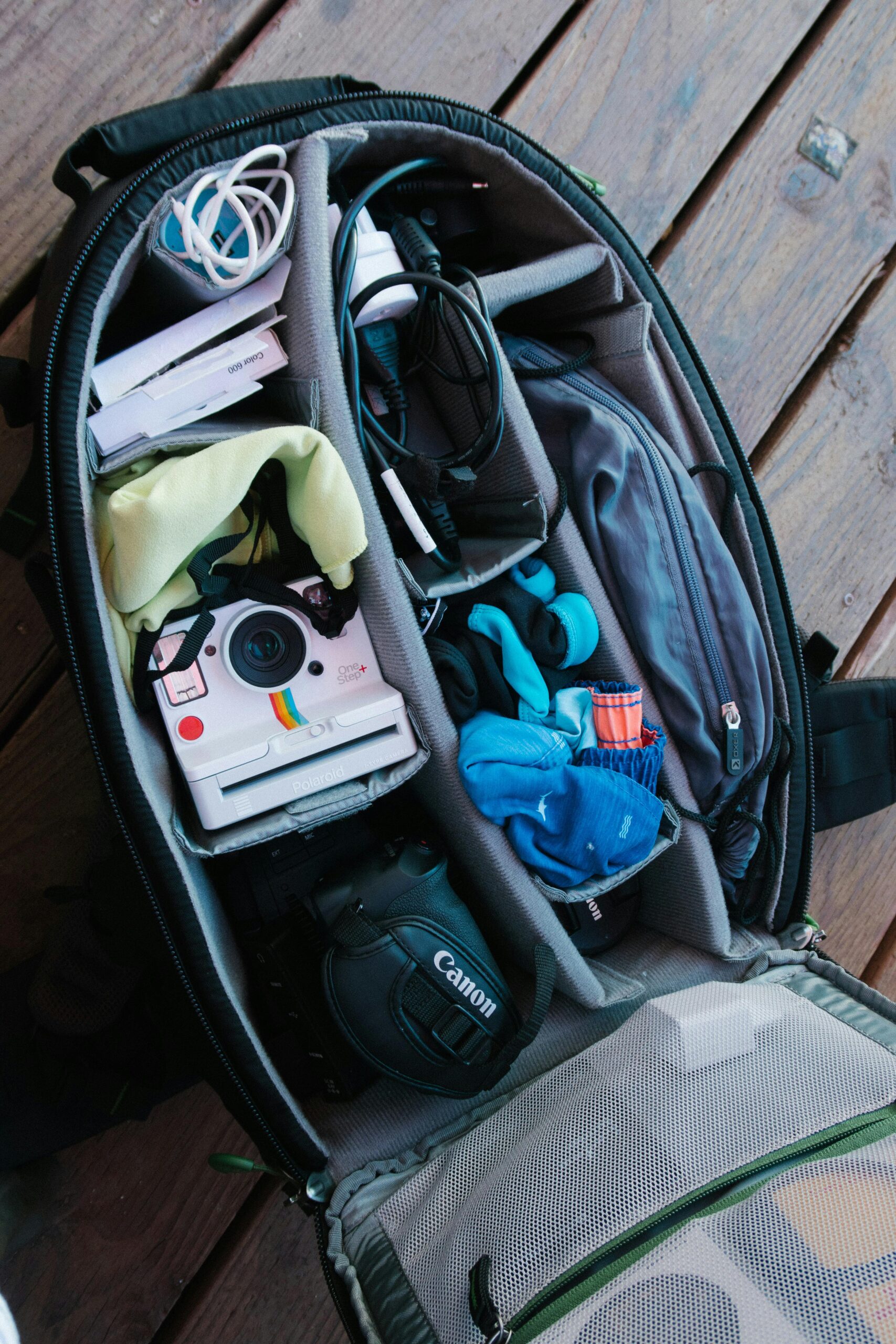 L'intérieur d'un sac avec 8 divisions où on retrouve deux caméras à gauche et du linge à droite.